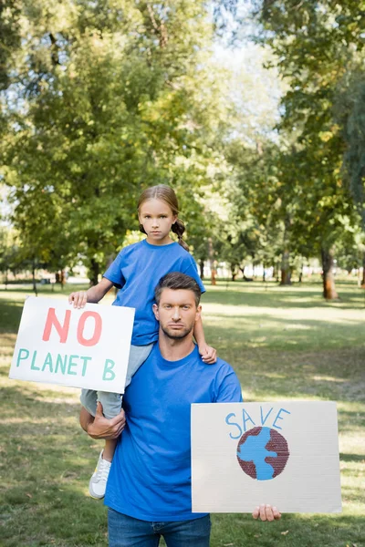 Padre e hija sosteniendo pancartas con globo y sin inscripción planeta b, concepto de ecología - foto de stock