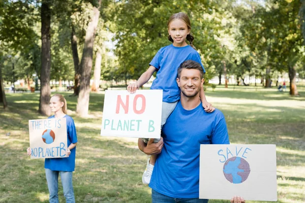 Glückliche Familie von Freiwilligen hält Plakate mit der Inschrift Planet b und Globus, Ökologie-Konzept — Stockfoto