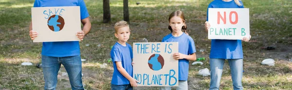 Family of activists holding placards with globe and there is no planet b inscription, ecology concept, banner — Stock Photo