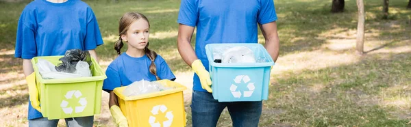 Menina com pais segurando recipientes com emblemas de reciclagem, cheio de lixo plástico, conceito de ecologia, bandeira — Stock Photo