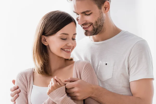 Feliz hombre abrazando alegre novia en casa - foto de stock