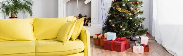 Wrapped presents under christmas tree in decorated and modern living room, banner — Stock Photo