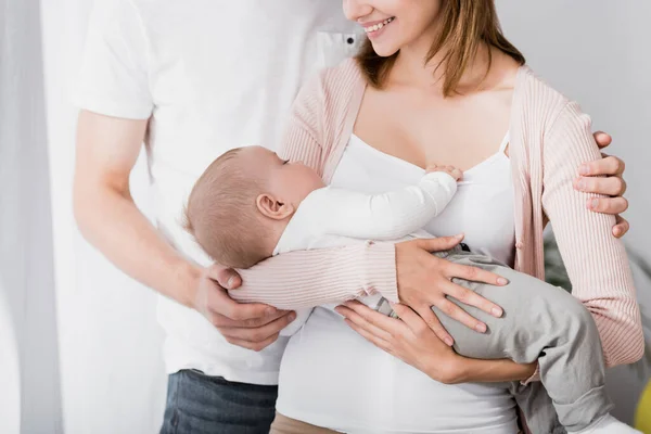 Souriante femme tenant dans les bras bébé garçon près de mari — Photo de stock