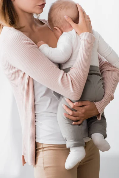 Ausgeschnittene Ansicht einer Mutter, die sich in den Armen hält, während sie ihren kleinen Sohn beruhigt — Stockfoto