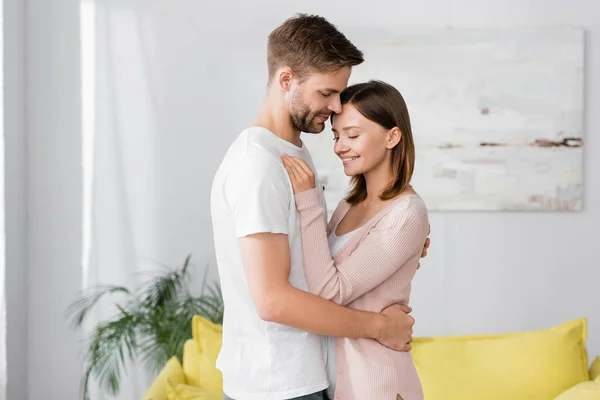 Homme heureux étreignant femme gaie à la maison — Photo de stock