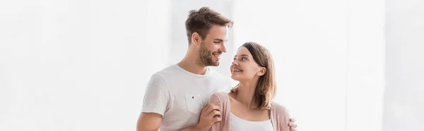 Happy man and woman looking at each other while hugging at home, banner — Stock Photo