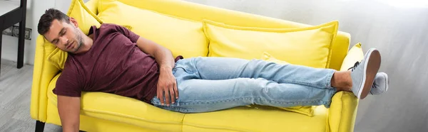 Young man sleeping on yellow couch at home, banner - foto de stock