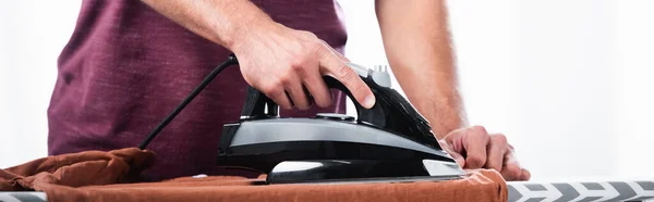 Cropped view of man ironing clothes on board at home, banner - foto de stock