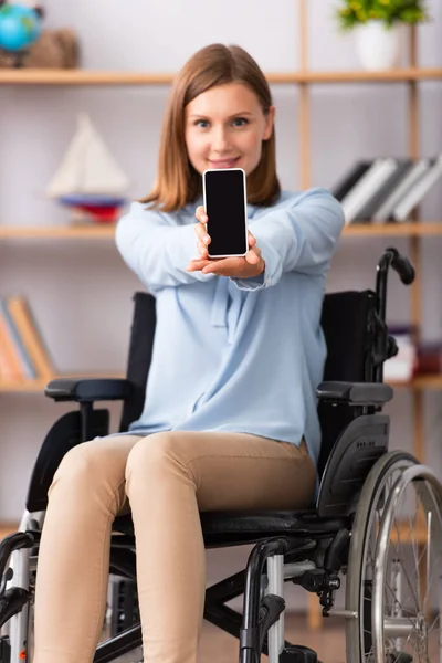 Smartphone avec écran vierge dans les mains du psychologue handicapé sur fond flou — Photo de stock