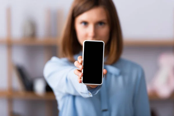 Smartphone with blank screen in hand of blurred psychologist on background — Stock Photo