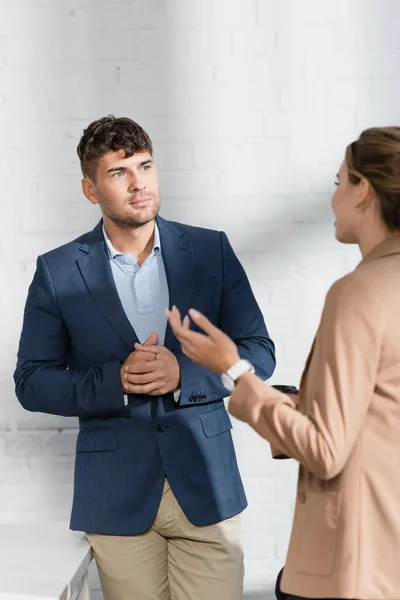 Бізнесмен дивиться на колегу-жіночу розмову під час перерви в офісі — стокове фото