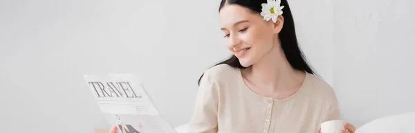 Femme gaie avec fleur dans les cheveux tenant tasse et lecture journal de voyage, bannière — Photo de stock