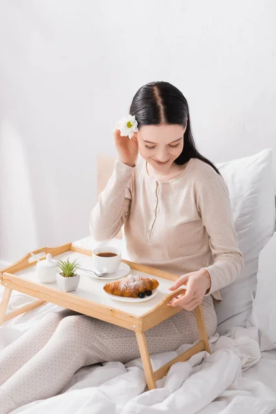 Happy woman with vitiligo looking at breakfast on tray — Stock Photo