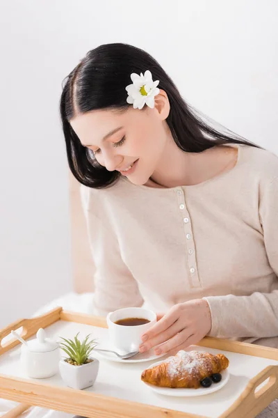 Femme brune heureuse avec vitiligo regardant le petit déjeuner sur le plateau — Photo de stock