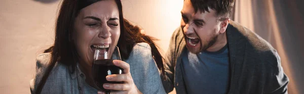 Aggressive, drunk man screaming at wife holding glass of wine, banner — Stock Photo