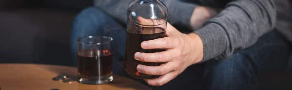 Vista recortada del hombre adicto al alcohol sosteniendo un vaso de whisky, pancarta - foto de stock