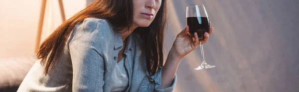 Vue recadrée d'une femme alcoolique tenant un verre de vin rouge, bannière — Photo de stock