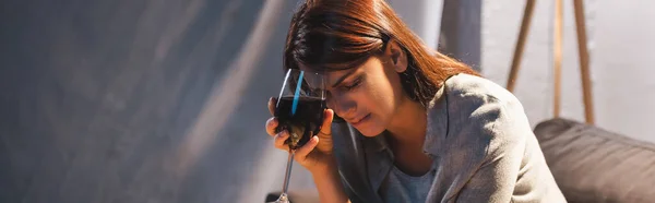 Depressed, drunk woman holding glass of red wine while sitting with closed eyes, banner — Stock Photo