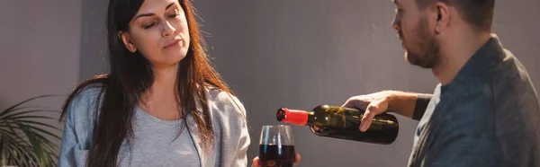 Husband pouring red wine into glass of wife, banner — Stock Photo