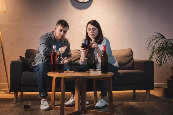 Marido y mujer bebiendo alcohol en casa juntos - foto de stock