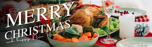 Table servie avec délicieuse tarte, dinde rôtie et légumes près de joyeux noël et heureux nouveau lettrage de l'année près de bougies, bannière — Photo de stock