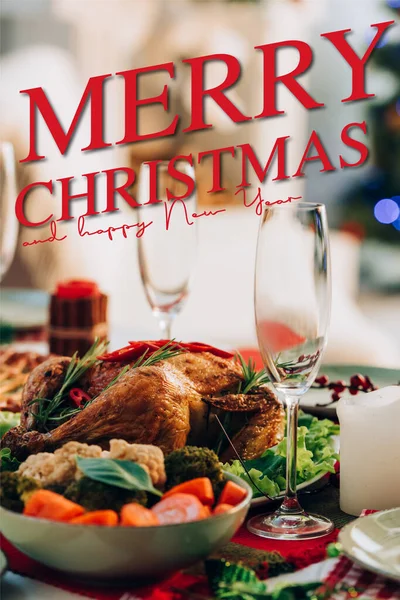Table servie avec une délicieuse dinde et légumes près de joyeux noël et heureux nouveau lettrage et verres de l'année — Photo de stock