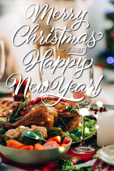 Table servie avec délicieuse dinde et légumes près de joyeux noël et heureux nouveau lettrage année et bougie — Photo de stock