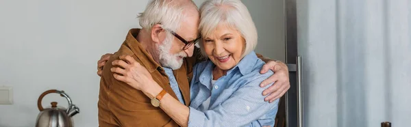 Cheerful senior couple hugging indoors, banner — Stock Photo