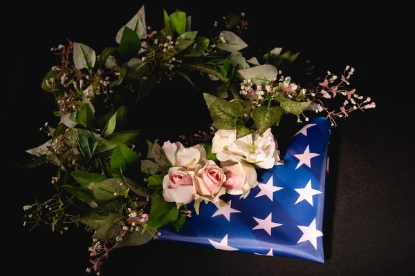 Couronne rose et drapeau américain sur fond noir, concept funéraire — Photo de stock