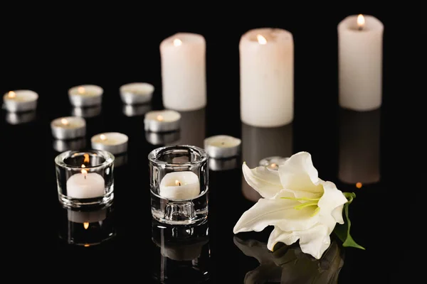 Lilie, Kerzen auf schwarzem Hintergrund, Bestattungskonzept — Stockfoto