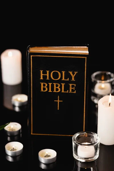 Candles and holy bible on black background, funeral concept — Stock Photo