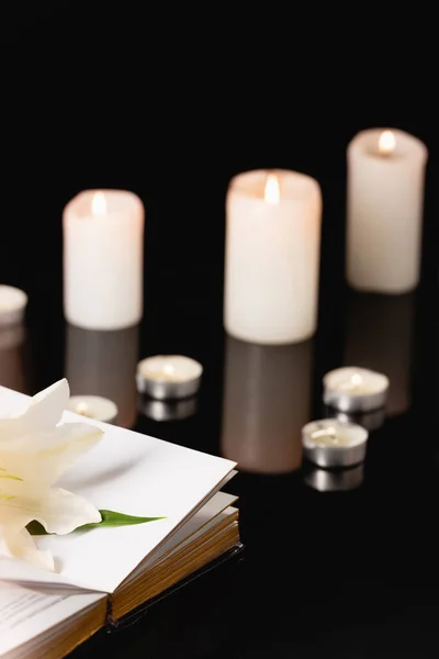 Lilie, Kerzen und Bibel auf schwarzem Hintergrund, Bestattungskonzept — Stockfoto