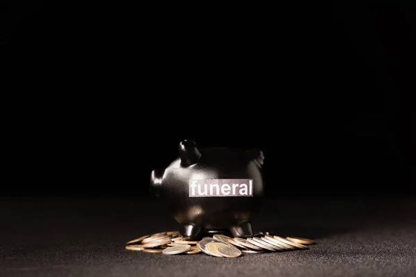Piggy bank with coins on black background, funeral concept — Stock Photo