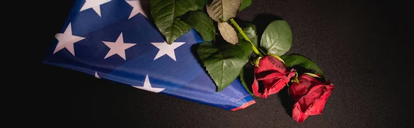 Vue du haut des roses rouges et drapeau américain sur fond noir, concept funéraire, bannière — Photo de stock