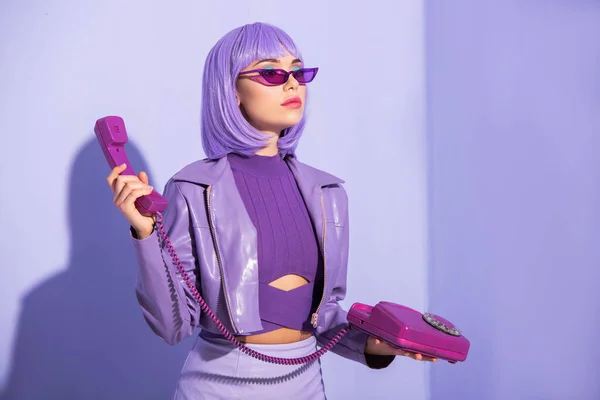Молода жінка, одягнена в ляльковий стиль з ретро телефоном на фіолетовому барвистому фоні — Stock Photo