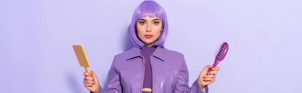 Mujer joven vestida con estilo de muñeca con cepillo de pelo y espejo sobre fondo de color violeta, pancarta — Stock Photo