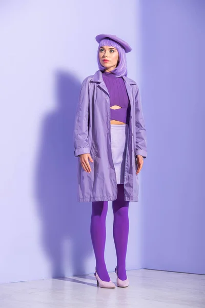 Молодая женщина в стиле куклы в берете позирует на фиолетовом красочном фоне — стоковое фото