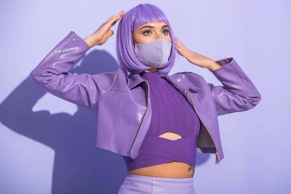 Jeune femme habillée de style poupée en masque médical sur fond violet coloré — Photo de stock