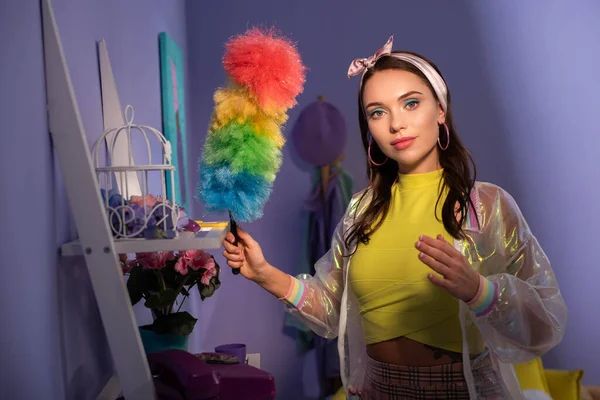 Young woman posing as doll with duster at home — Stock Photo