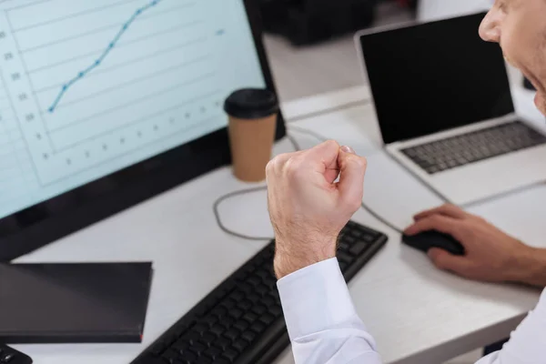 Vista recortada del hombre de negocios mostrando sí gesto mientras se utiliza la computadora con gráfico en fondo borroso - foto de stock