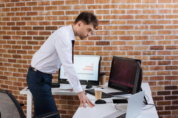 Focused businessman checking finance stocks on computers in office — Stock Photo