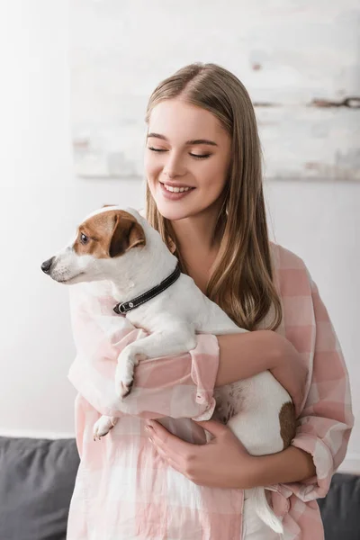 Alegre joven mujer celebración en armas jack russell terrier - foto de stock