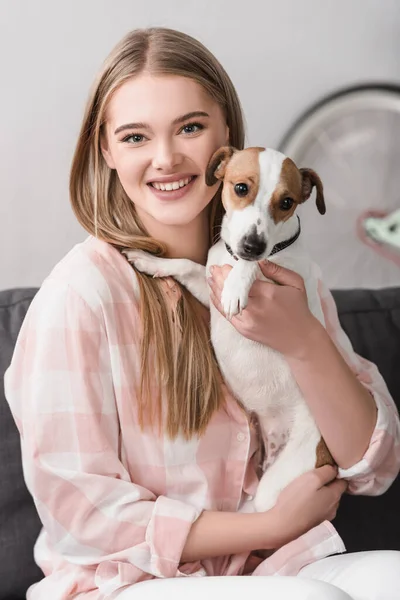 Donna sorridente che tiene in braccio jack russell terrier — Foto stock