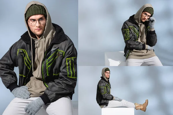 Collage eines trendigen Mannes mit Hut, Handschuhen und Parka mit einer Hand auf der Hüfte, die auf einem weißen Würfel sitzt und einer regulierenden Brille auf grau — Stockfoto