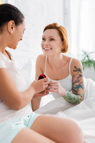 African american woman holding jewelry box while making wedding proposal to happy lesbian girlfriend — Stock Photo