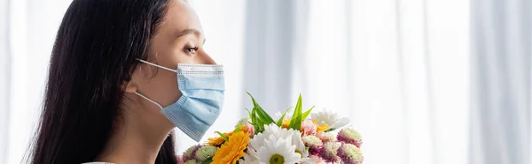 Vue latérale de la femme allergique dans le masque médical avec des fleurs à la maison, bannière — Stock Photo