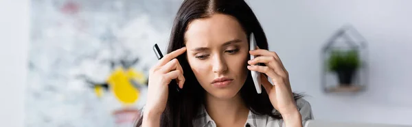 Засмучена жінка говорить на мобільному телефоні, тримаючи ручку, банер — стокове фото