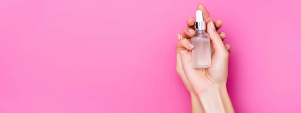 Visão superior de mãos femininas preparadas com frasco de removedor de cutícula no fundo rosa, banner — Fotografia de Stock