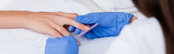 Vista cortada de manicure usando o arquivo de unhas ao fazer manicure ao cliente, foreground borrado, banner — Fotografia de Stock