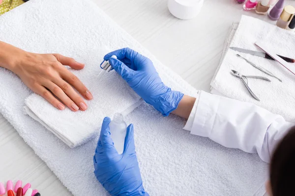 Abgeschnittene Ansicht des Maniküre-Maniküre Anwendung Nagelhautentferner auf Finger des Kunden mit Pipette — Stockfoto